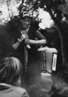 Jo Clayton storytelling to a crowd of people in a forest